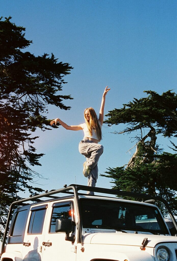 Woman standing on top of jeep