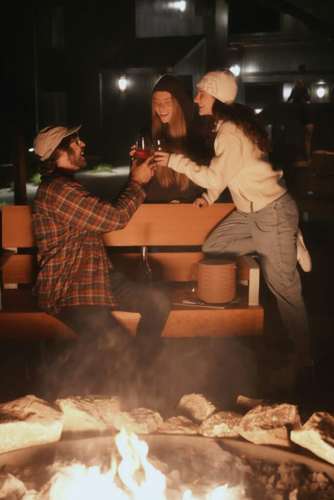 Friends drinking wine around the fire pit