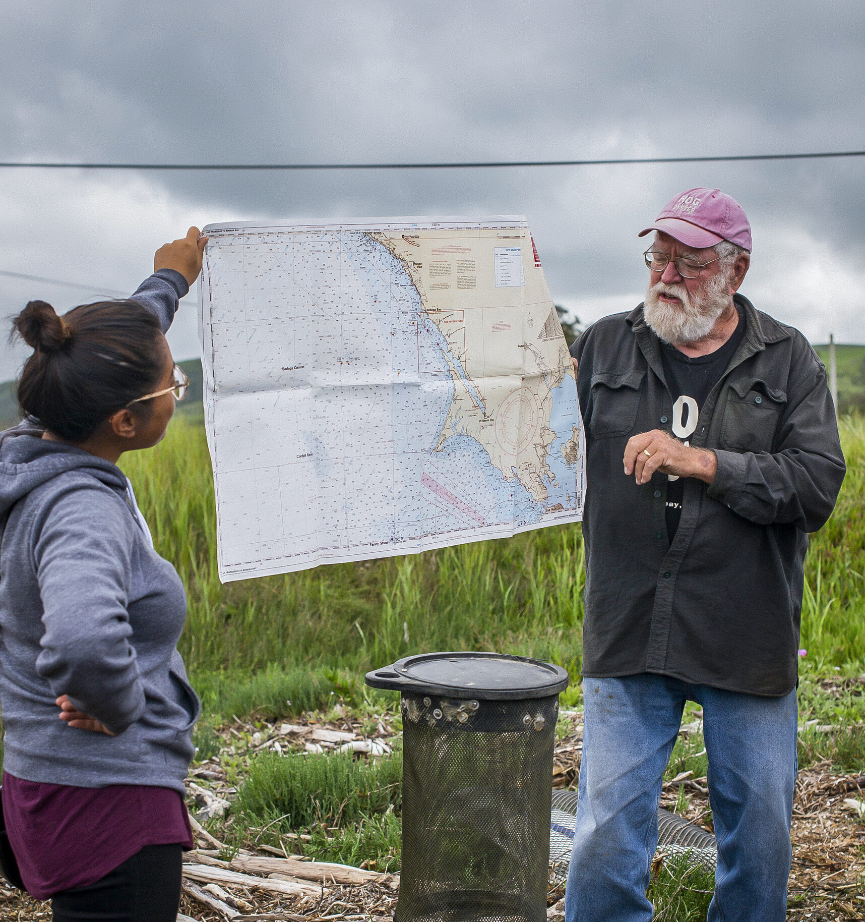 Older Man With Woman Holding Up Map Outdoors