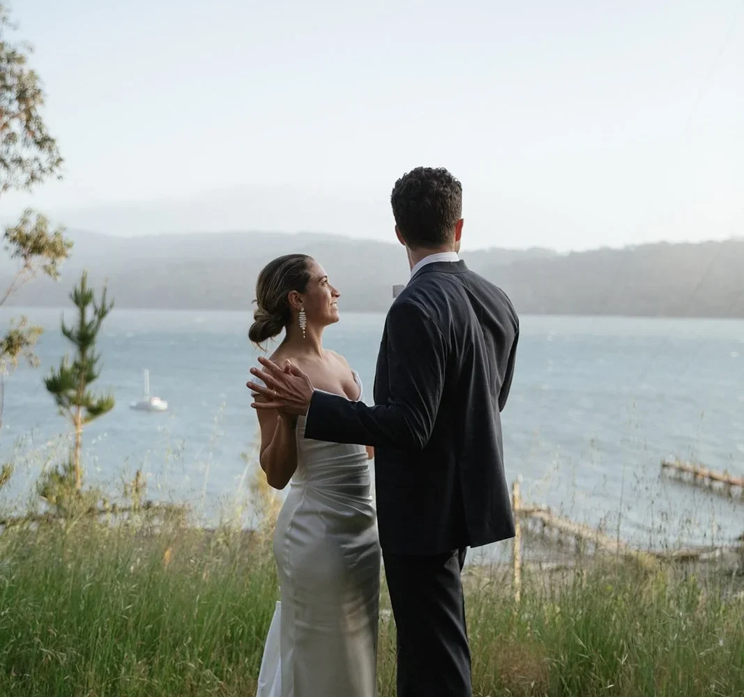 Couple in wedding attire holding hands and looking at view