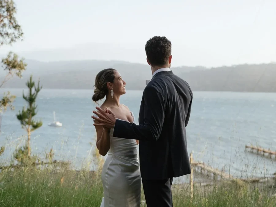 Couple in wedding attire holding hands and looking at view